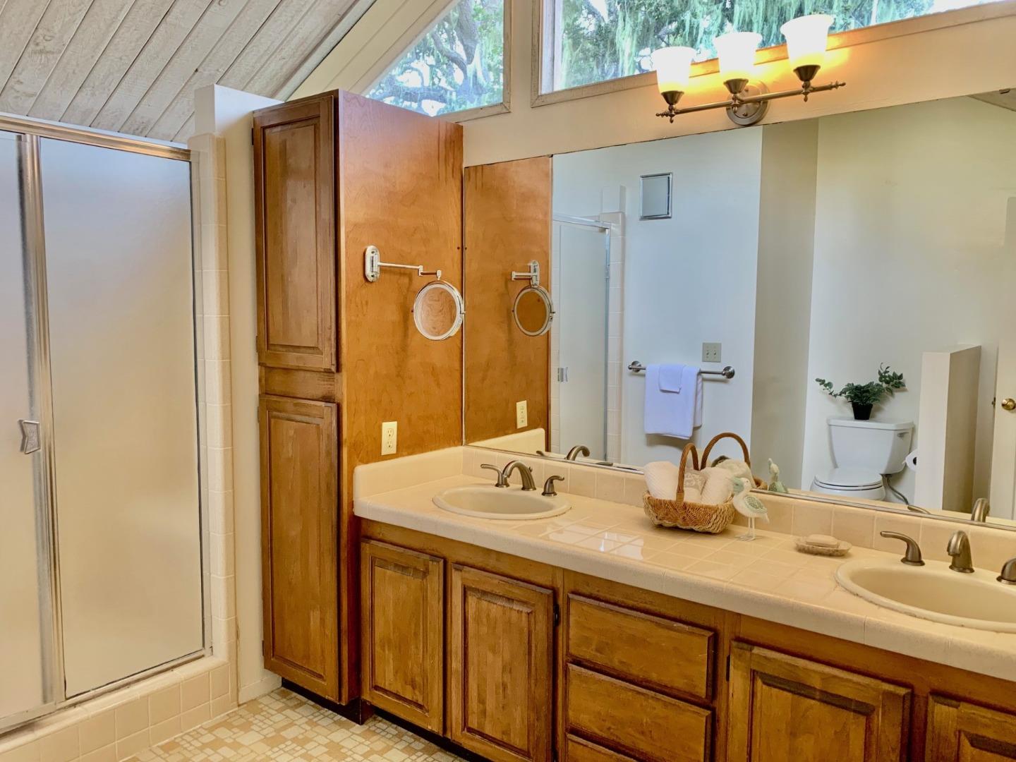 1012 San Carlos Road Pebble Beach, CA 93953 - Photo 12 of 20 a bathroom with a double vanity sink and a mirror