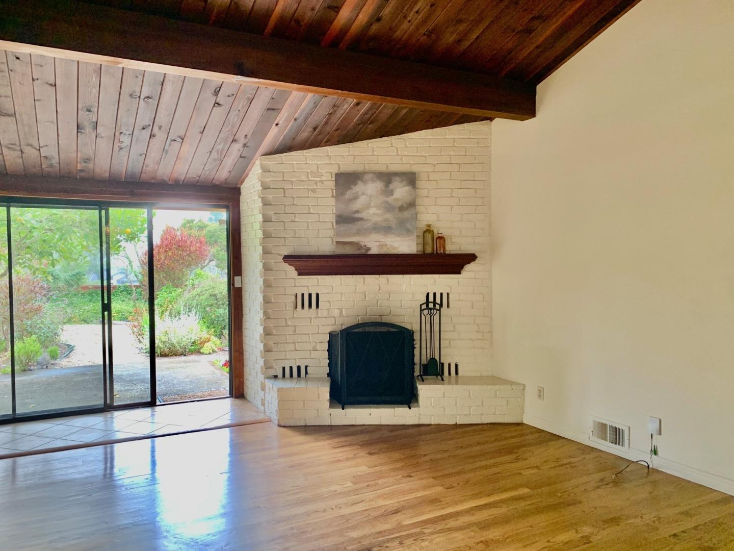 1012 San Carlos Road Pebble Beach, CA 93953 - Photo 3 of 20 a view of an empty room with wooden floor and a fireplace