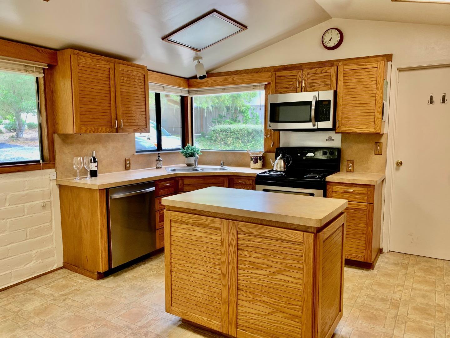 1012 San Carlos Road Pebble Beach, CA 93953 - Photo 6 of 20 a kitchen with stainless steel appliances granite countertop a sink a stove and a microwave