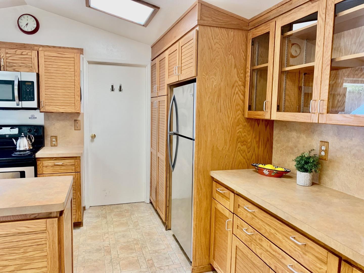 1012 San Carlos Road Pebble Beach, CA 93953 - Photo 7 of 20 a kitchen with a sink a refrigerator and cabinets