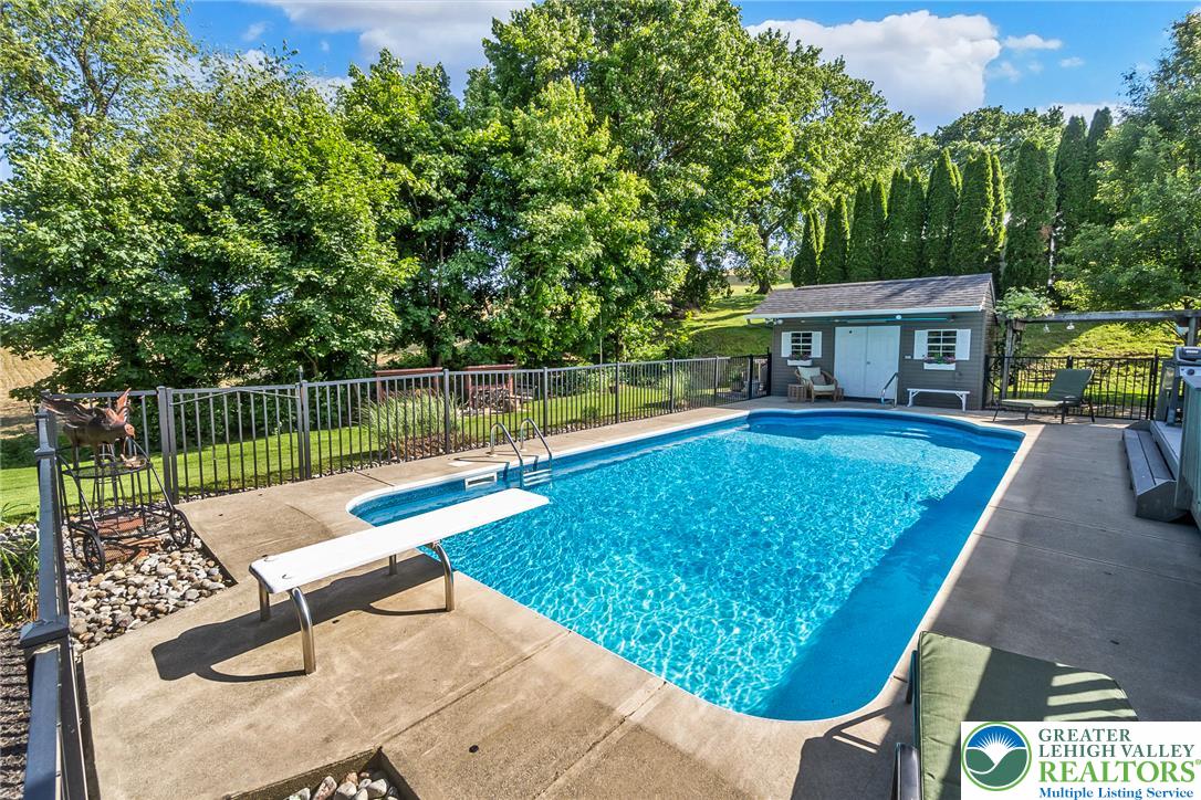 540 Briar Road Pen Argyl, PA 18072 - Photo 41 of 66 A tranquil backyard oasis features a glistening inground pool, surrounded by mature trees and a charming Pool house
