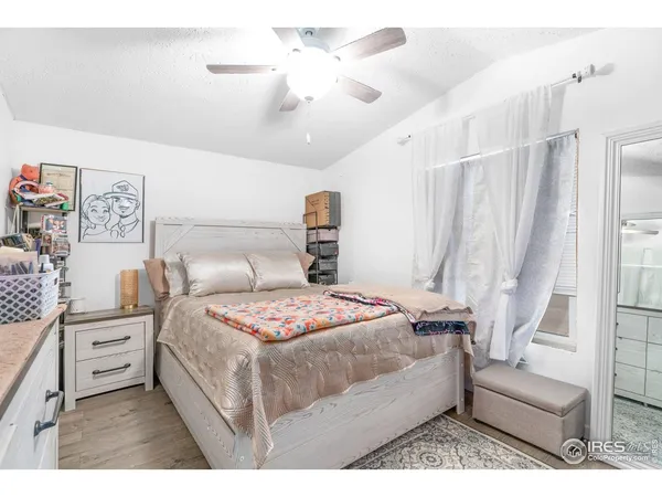 a bedroom with a bed a couch and a chandelier