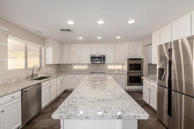 a large kitchen with a large window and stainless steel appliances
