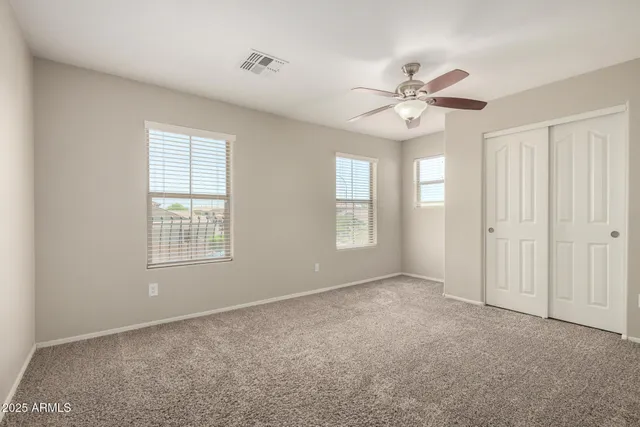 a view of an empty room with a window and a fan