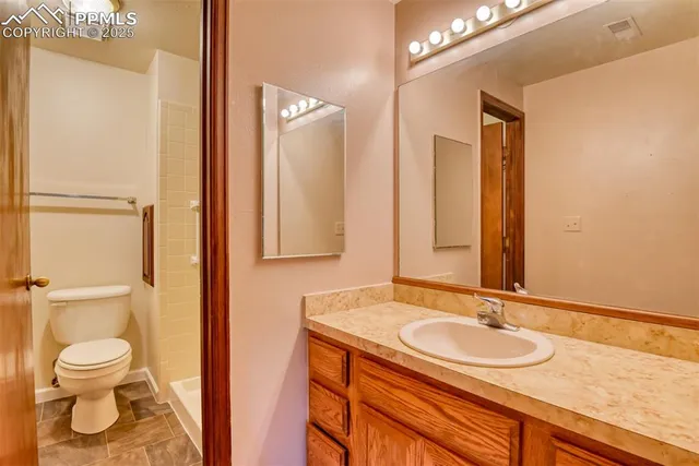 an aerial view of a house with swimming pool and large trees