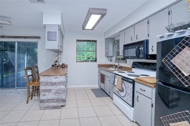 a kitchen with stainless steel appliances a stove a sink cabinets and a window