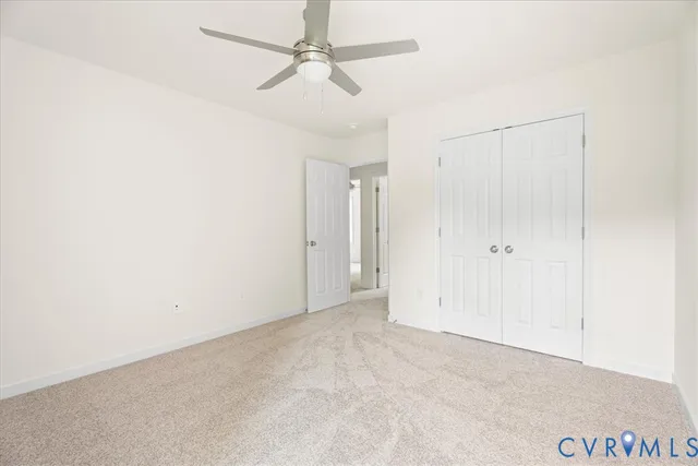 an empty room with a ceiling fan and a window