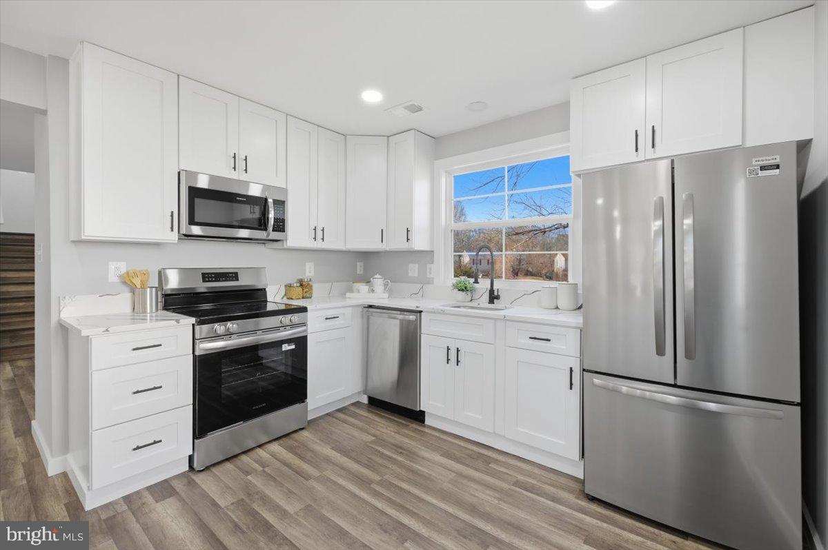 4529 Flintstone Road Alexandria, VA 22306 - Photo 23 of 37 Modern kitchen with sleek white cabinetry.