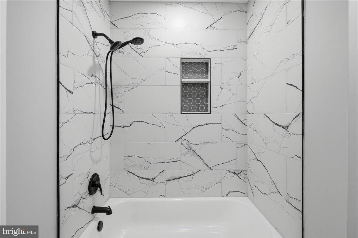 4529 Flintstone Road Alexandria, VA 22306 - Photo 9 of 37 Sleek marble shower with modern fixtures.