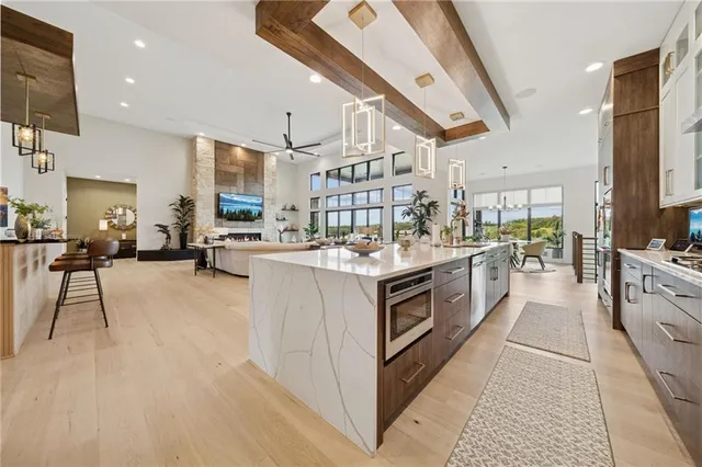 a kitchen with stainless steel appliances kitchen island granite countertop a stove and a sink