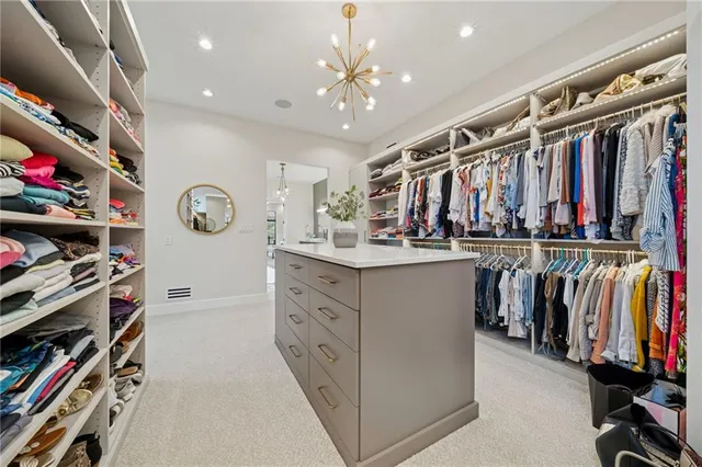 a view of walk in closet with clothes and shoes
