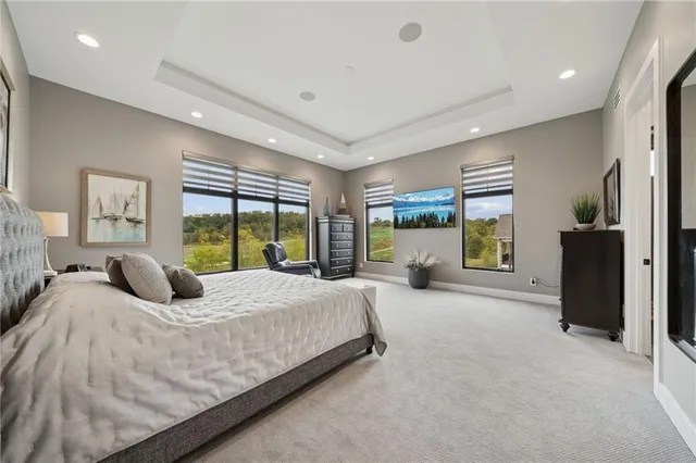 a bedroom with a balcony a large bed and a large window