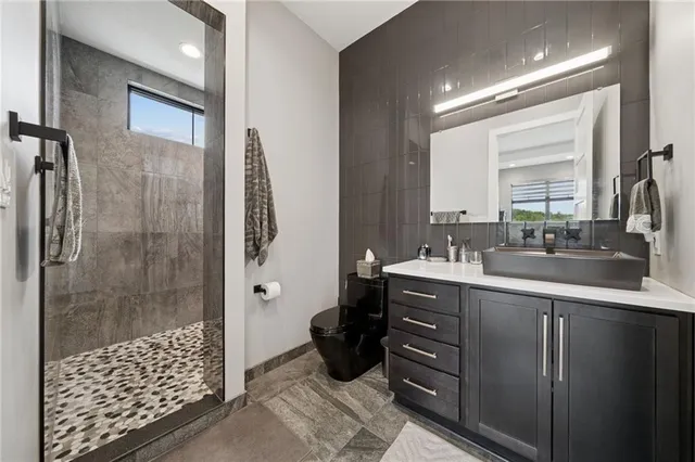 a bathroom with a double vanity sink toilet and shower