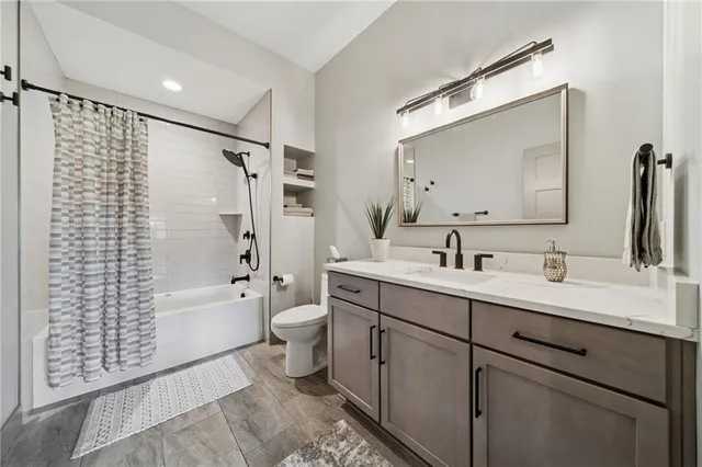 a bathroom with a double vanity sink toilet mirror and bathtub