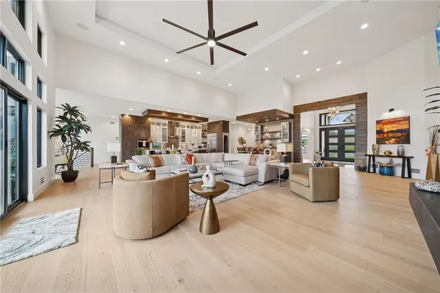 a living room with furniture kitchen view and a chandelier