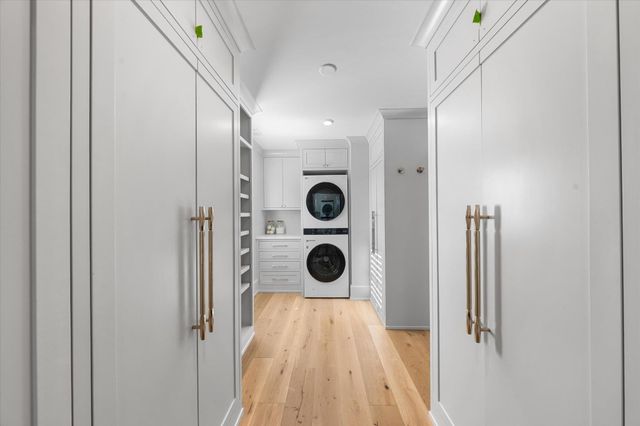 a view of a hallway to closet and front door