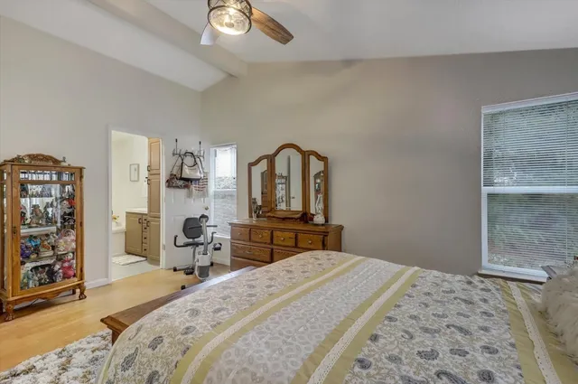 a bedroom with a bed and dresser with mirror