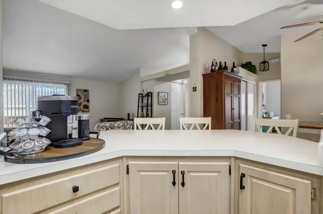 a view of living room with granite countertop white cabinets and white appliances