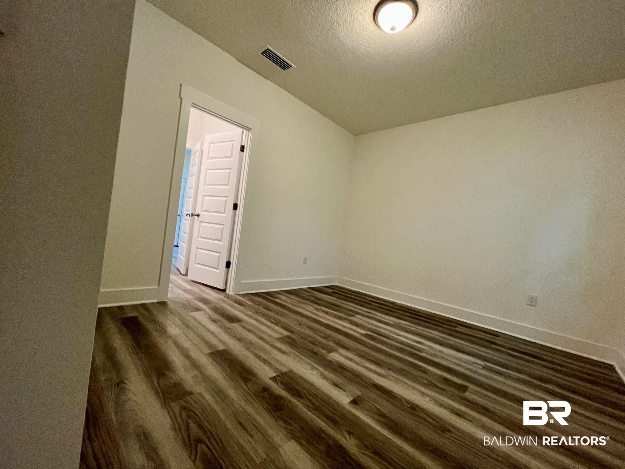 334 Barndling Street Fairhope, AL 36532 - Photo 18 of 34 Unfurnished room featuring dark hardwood / wood-style flooring and a textured ceiling