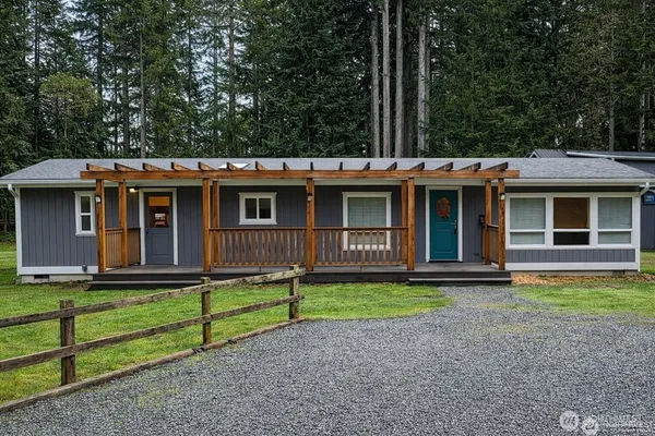 a view of a house with a yard and large tree