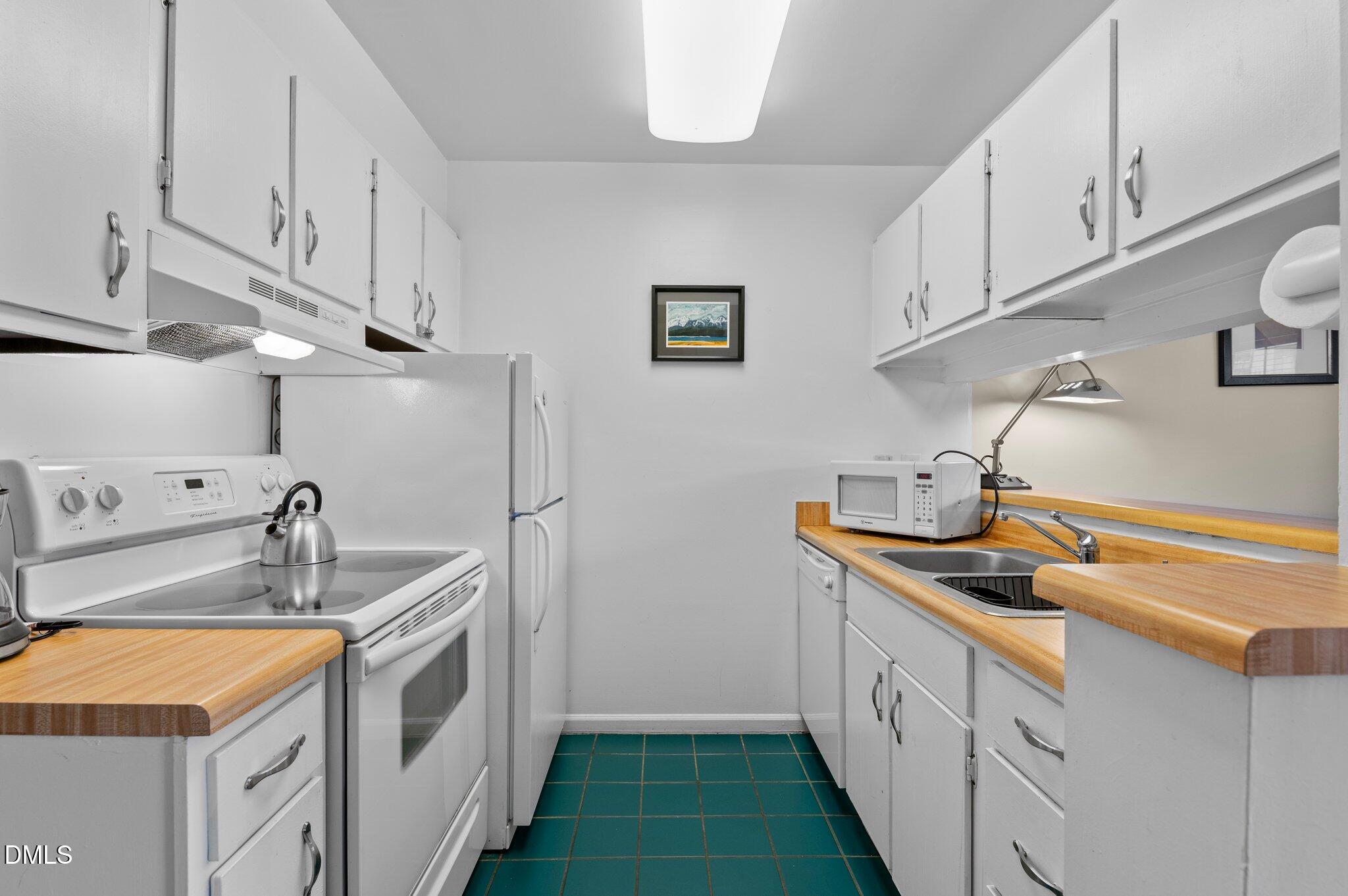 807 West Trinity Avenue, Unit 153 Durham, NC 27701 - Photo 9 of 39 a kitchen with stainless steel appliances granite countertop a sink and dishwasher a stove with wooden cabinets