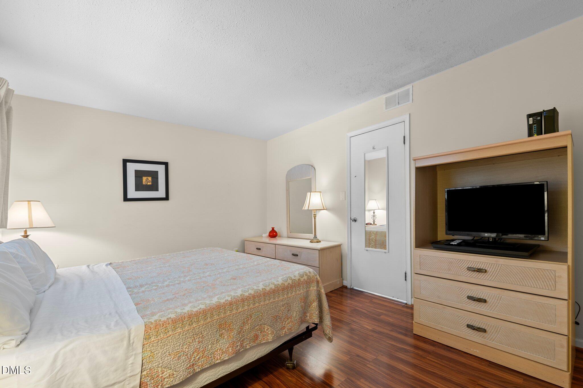 807 West Trinity Avenue, Unit 153 Durham, NC 27701 - Photo 14 of 39 a bedroom with a bed and a flat screen tv