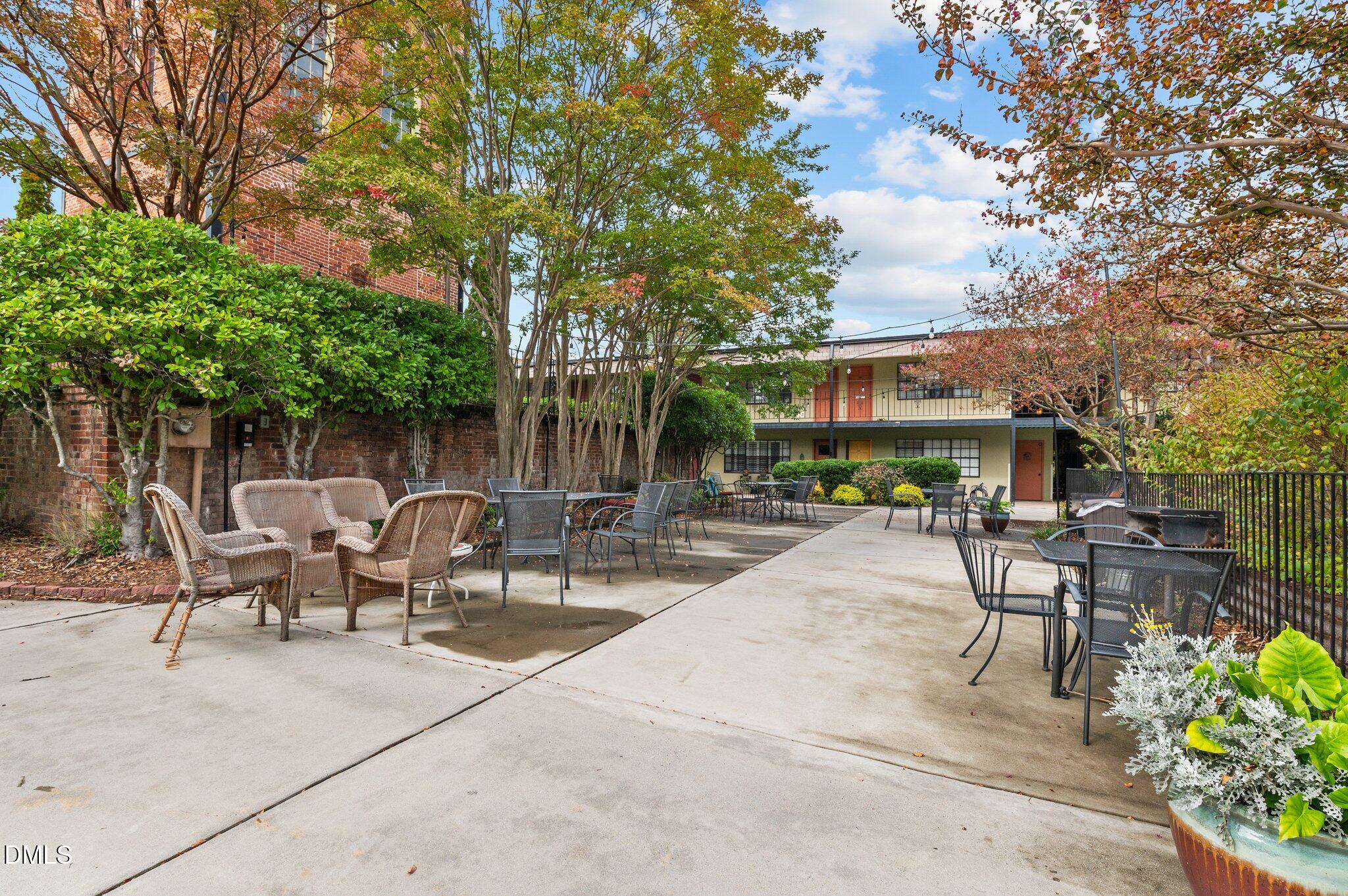 807 West Trinity Avenue, Unit 153 Durham, NC 27701 - Photo 18 of 39 a view of backyard with a table and chairs and potted plants and large trees