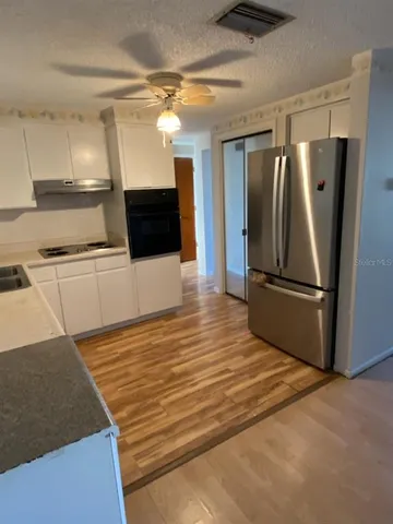 a kitchen with granite countertop a refrigerator and a sink