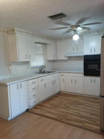 a kitchen with a sink cabinets and window