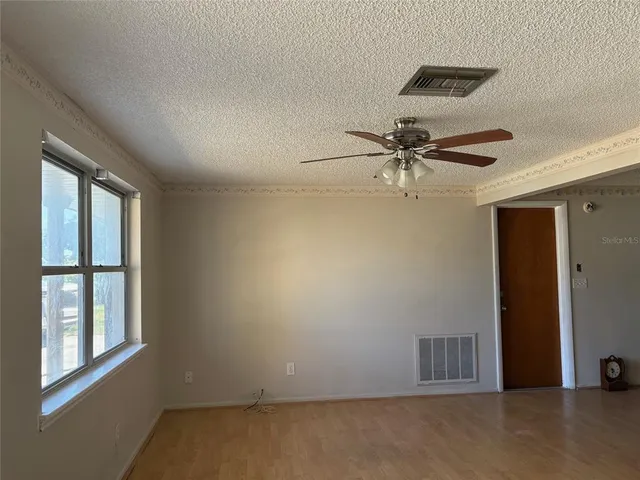 a view of a livingroom with a ceiling fan and window