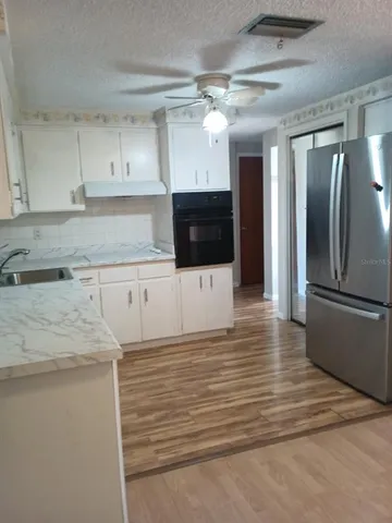 a kitchen with stainless steel appliances a refrigerator and a stove top oven