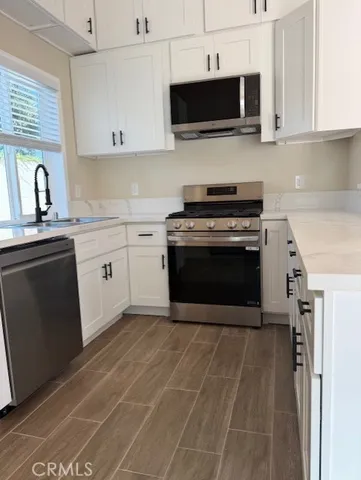a kitchen with stainless steel appliances granite countertop a granite counter tops and white cabinets