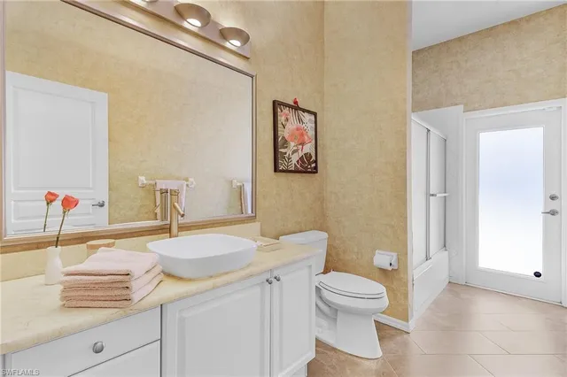 a bathroom with a granite countertop sink mirror vanity and toilet