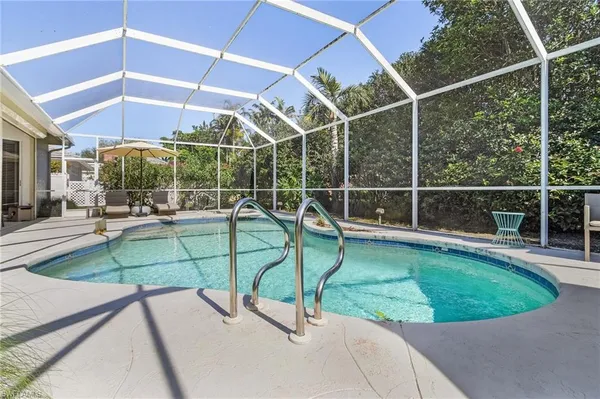 a view of a swimming pool with a patio and a backyard