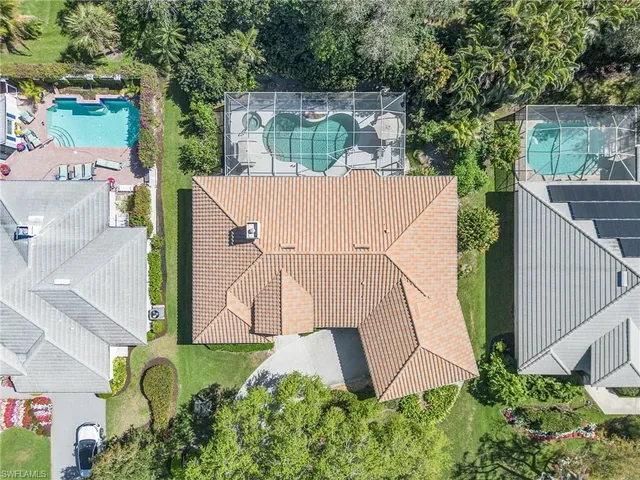 an aerial view of a house with backyard and trees