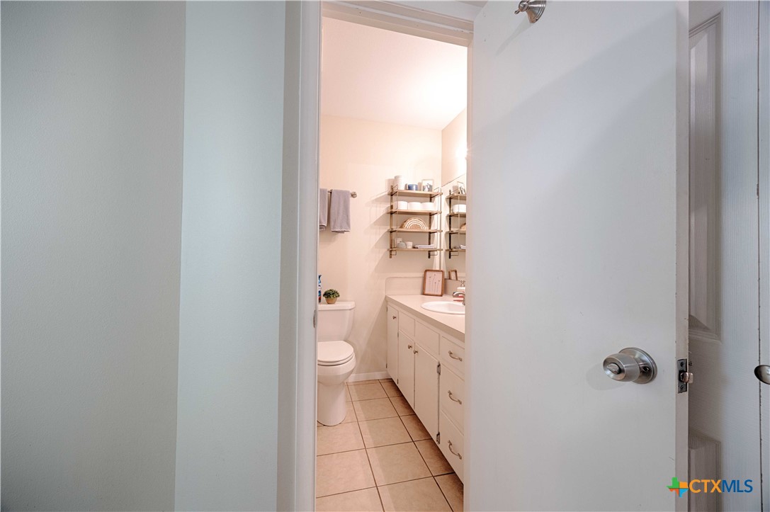 207 River Street Hallettsville, TX 77964 - Photo 15 of 25 a bathroom with a granite countertop toilet and a sink