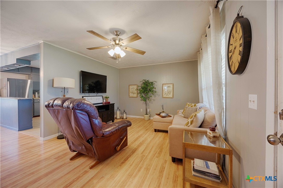 207 River Street Hallettsville, TX 77964 - Photo 5 of 25 a living room with furniture a fireplace and a flat screen tv