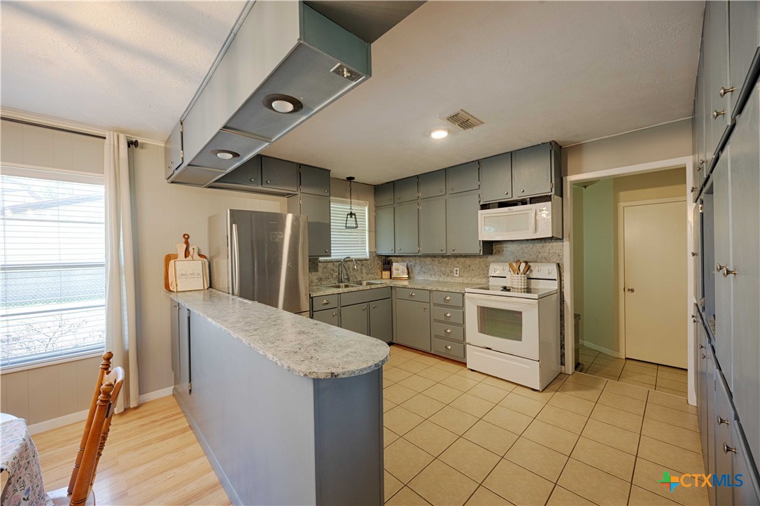 207 River Street Hallettsville, TX 77964 - Photo 7 of 25 a large kitchen with a stove a refrigerator and a sink