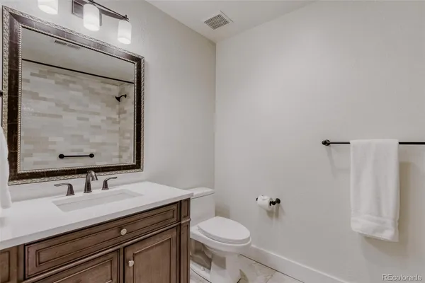 a bathroom with a granite countertop sink toilet and shower