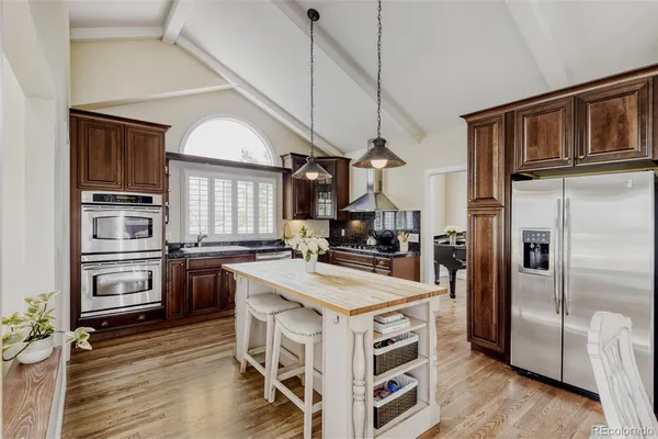 a kitchen with stainless steel appliances a stove refrigerator and cabinets