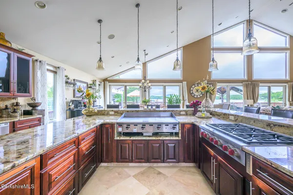 a kitchen with stainless steel appliances granite countertop a stove a sink dishwasher and cabinets with wooden floor