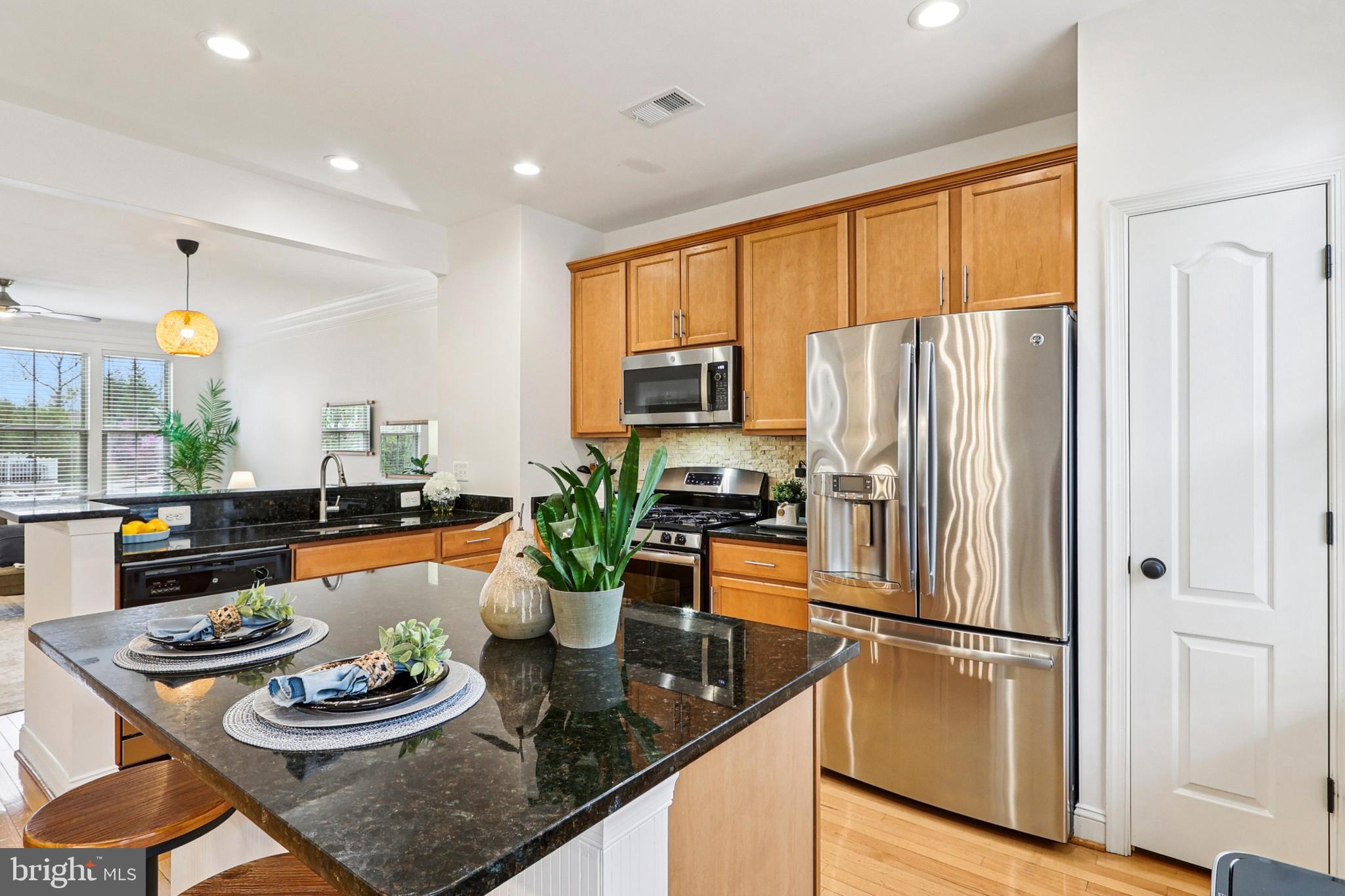 4505 Potomac Highlands Circle Triangle, VA 22172 - Photo 19 of 65 a kitchen with stainless steel appliances granite countertop a refrigerator a sink a stove and a dining table with wooden floor
