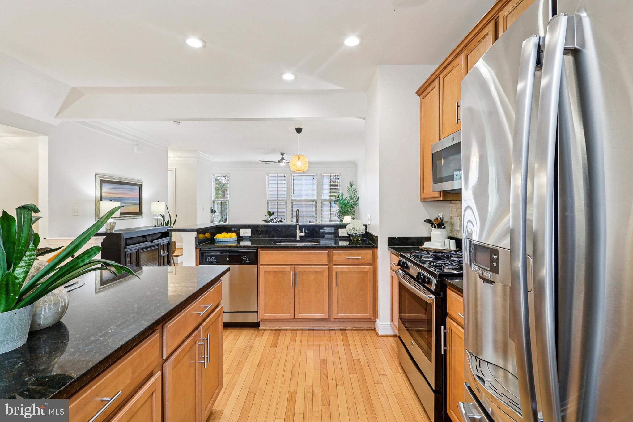 4505 Potomac Highlands Circle Triangle, VA 22172 - Photo 20 of 65 a kitchen with stainless steel appliances granite countertop a refrigerator a sink dishwasher a stove and white countertops with wooden floor