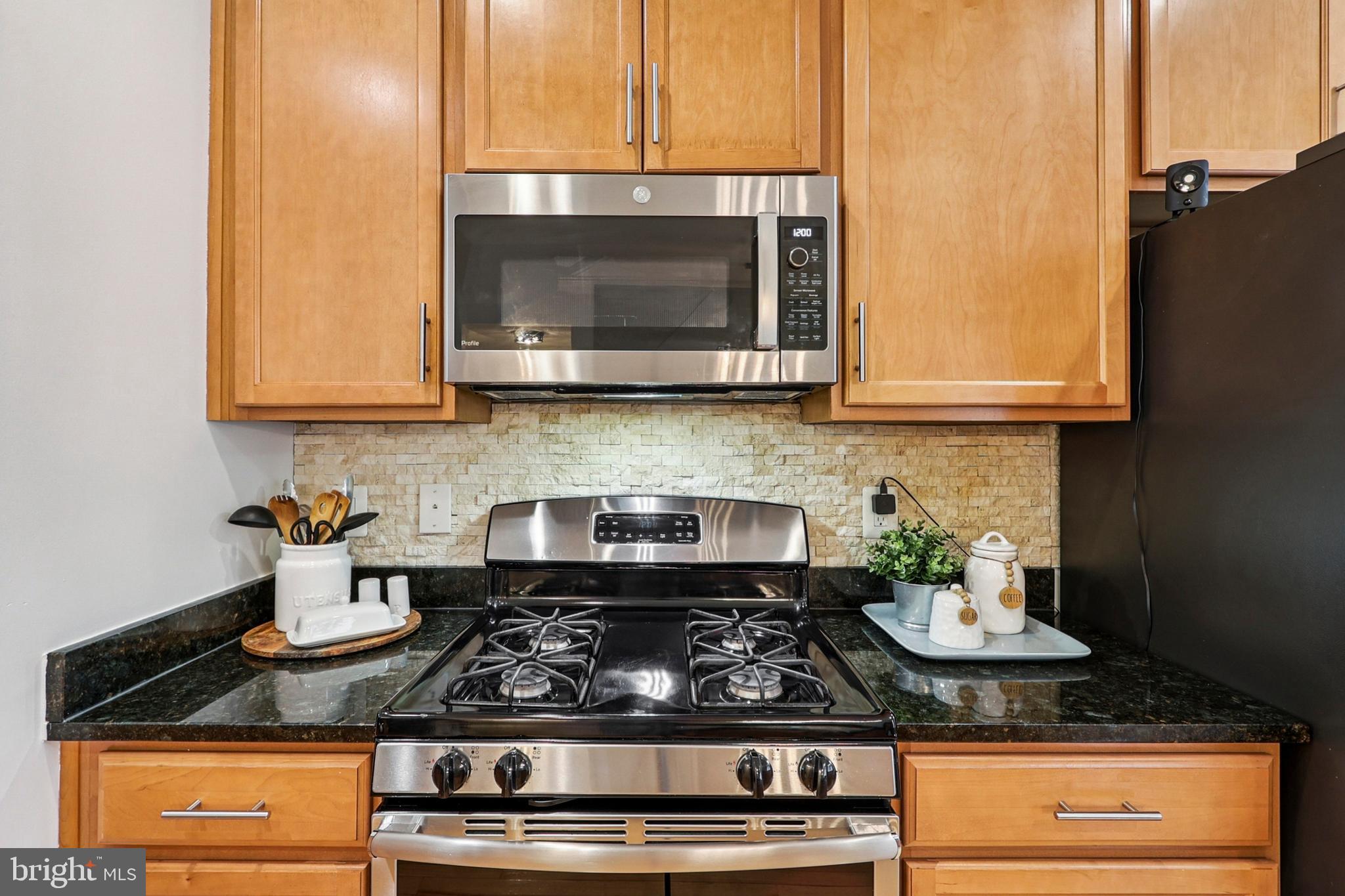 4505 Potomac Highlands Circle Triangle, VA 22172 - Photo 23 of 65 a kitchen with stainless steel appliances granite countertop a stove a microwave and cabinets