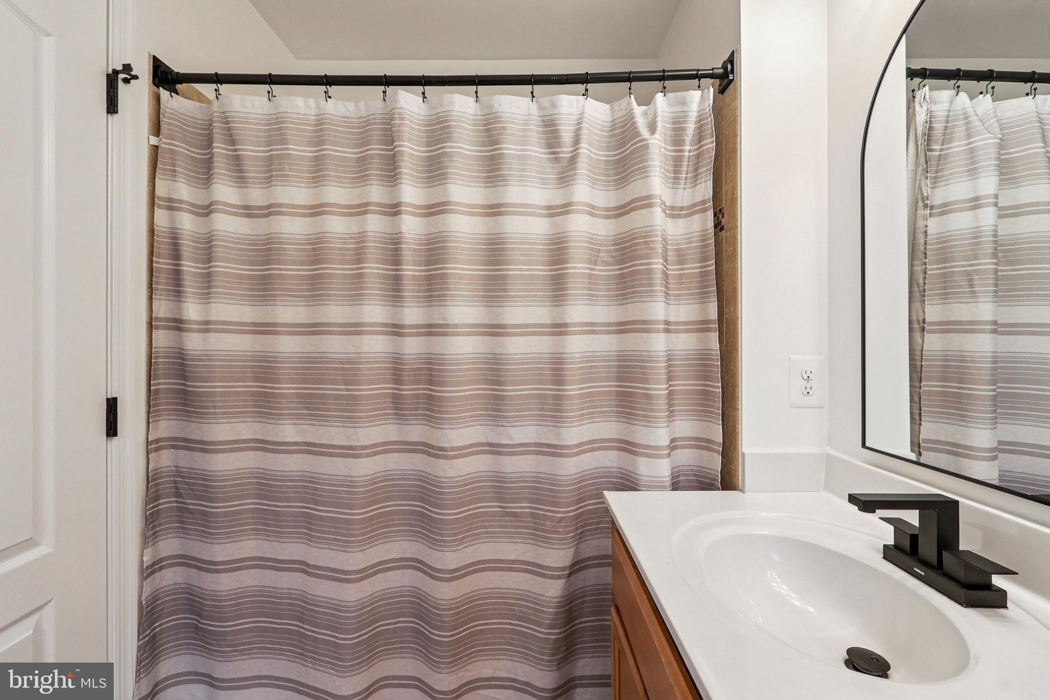 4505 Potomac Highlands Circle Triangle, VA 22172 - Photo 44 of 65 a bathroom with a sink and a shower curtain