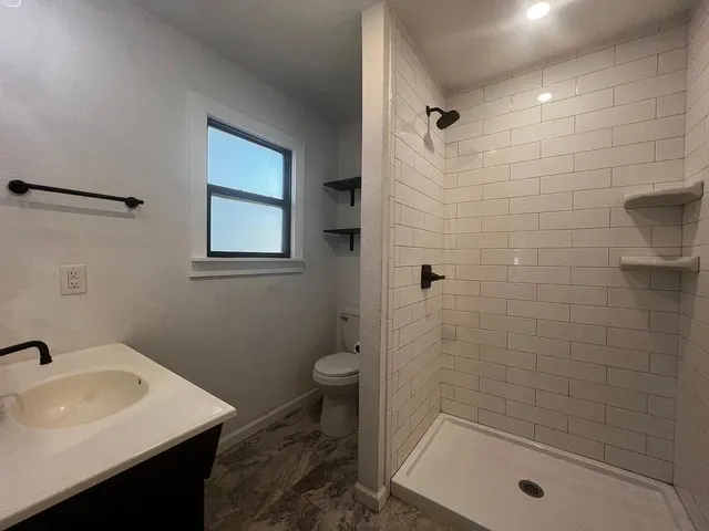 a bathroom with a sink a toilet and shower