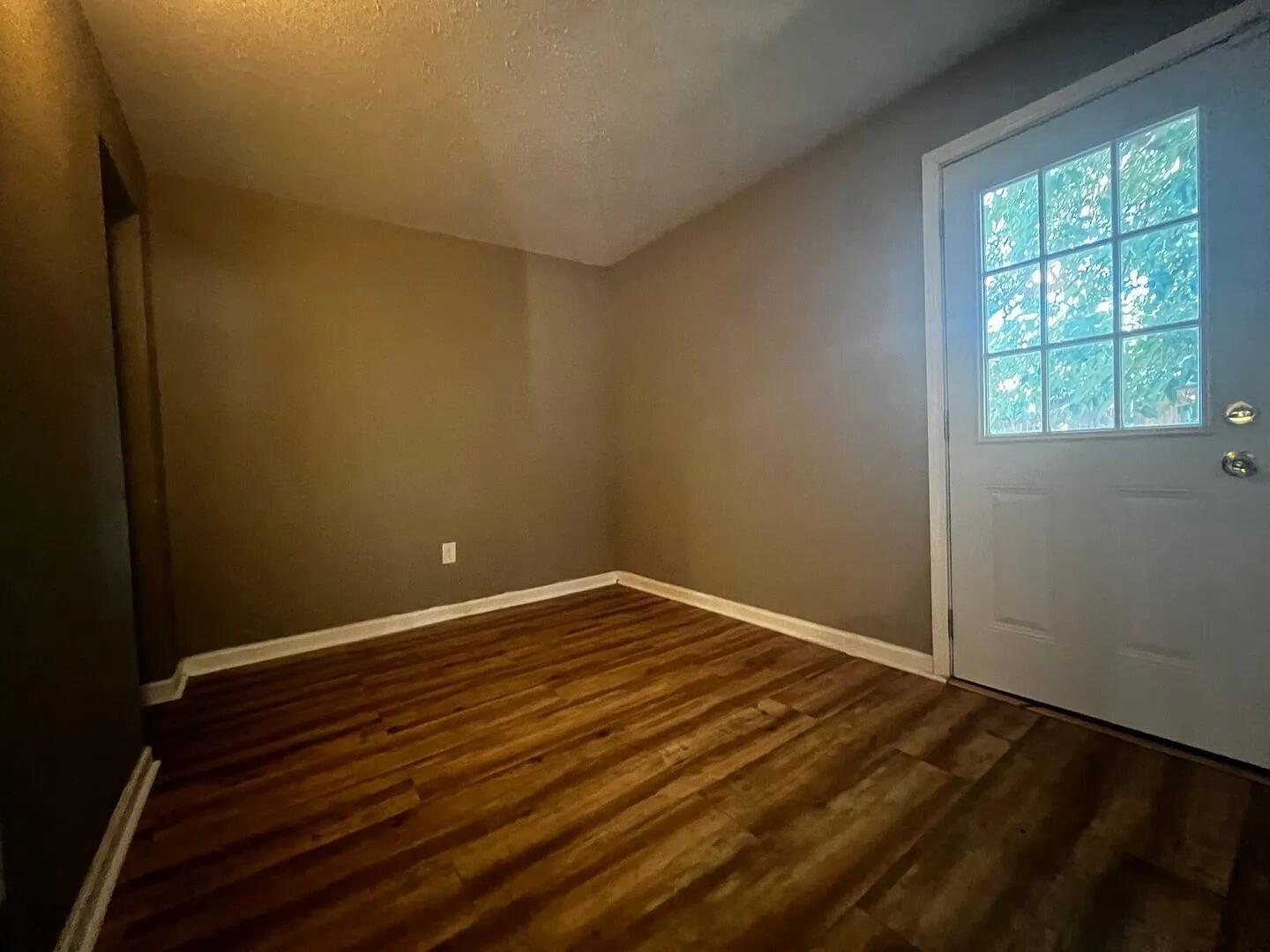 4906 60th Street Lubbock, TX 79414 - Photo 3 of 7 an empty room with wooden floor and windows