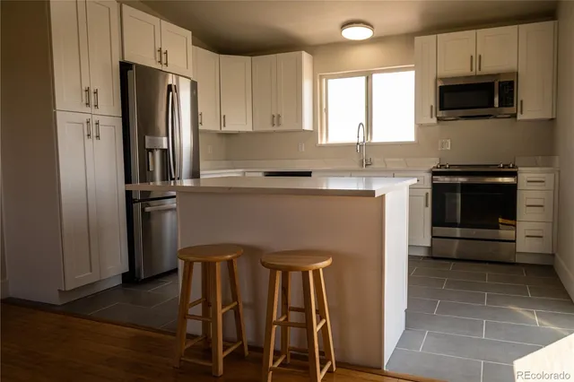 a kitchen with stainless steel appliances granite countertop a stove refrigerator sink and microwave