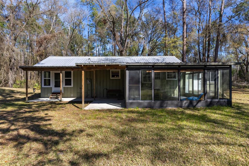 1317 Northeast Drew Road Lake City, FL 32055 - Photo 9 of 32 a view of a house with a large window and a yard with chairs