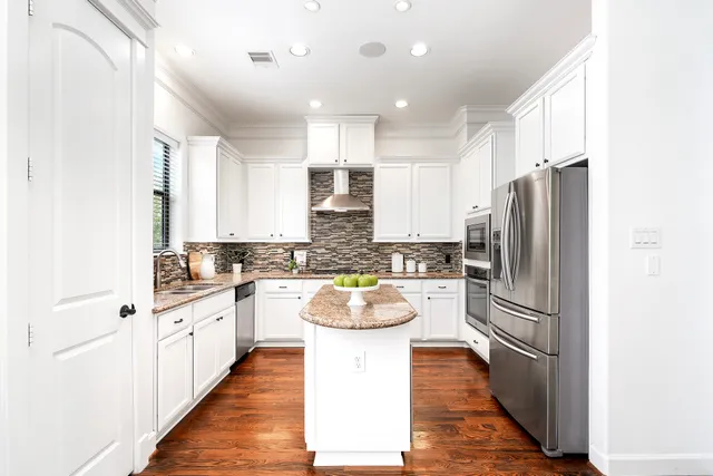 a kitchen with stainless steel appliances granite countertop a refrigerator and a sink